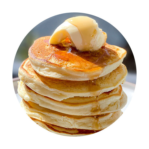Stack of fluffy buttermilk pancakes topped with butter and syrup